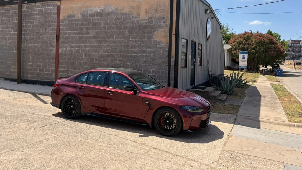 Red BMW performance sedan photographed outside Cedar Performance in Dallas
