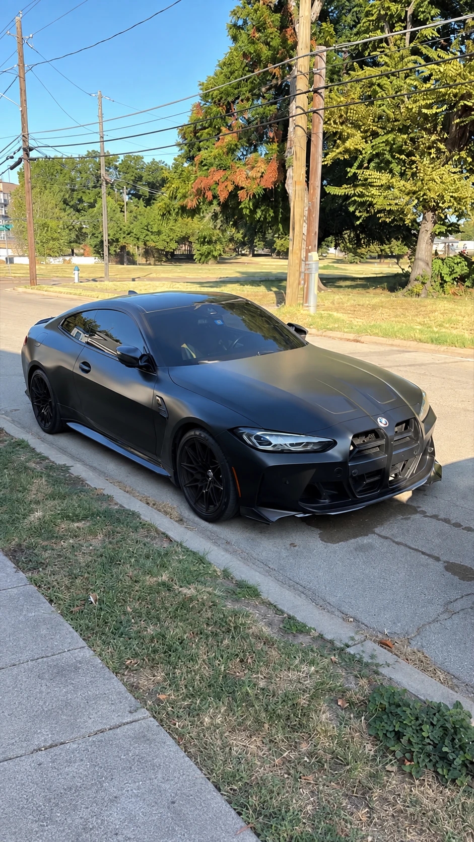 Dark BMW M4 coupe parked beside Cedar Performance in Dallas