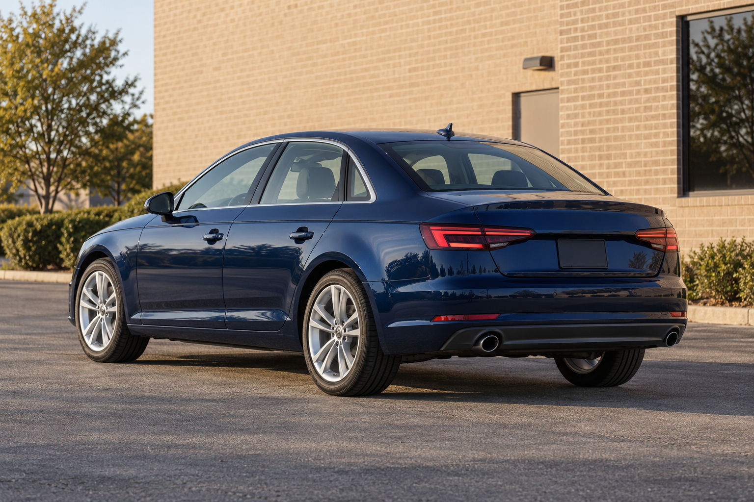 Illustrative blue Audi A4 B9 sedan beside a brick commercial building