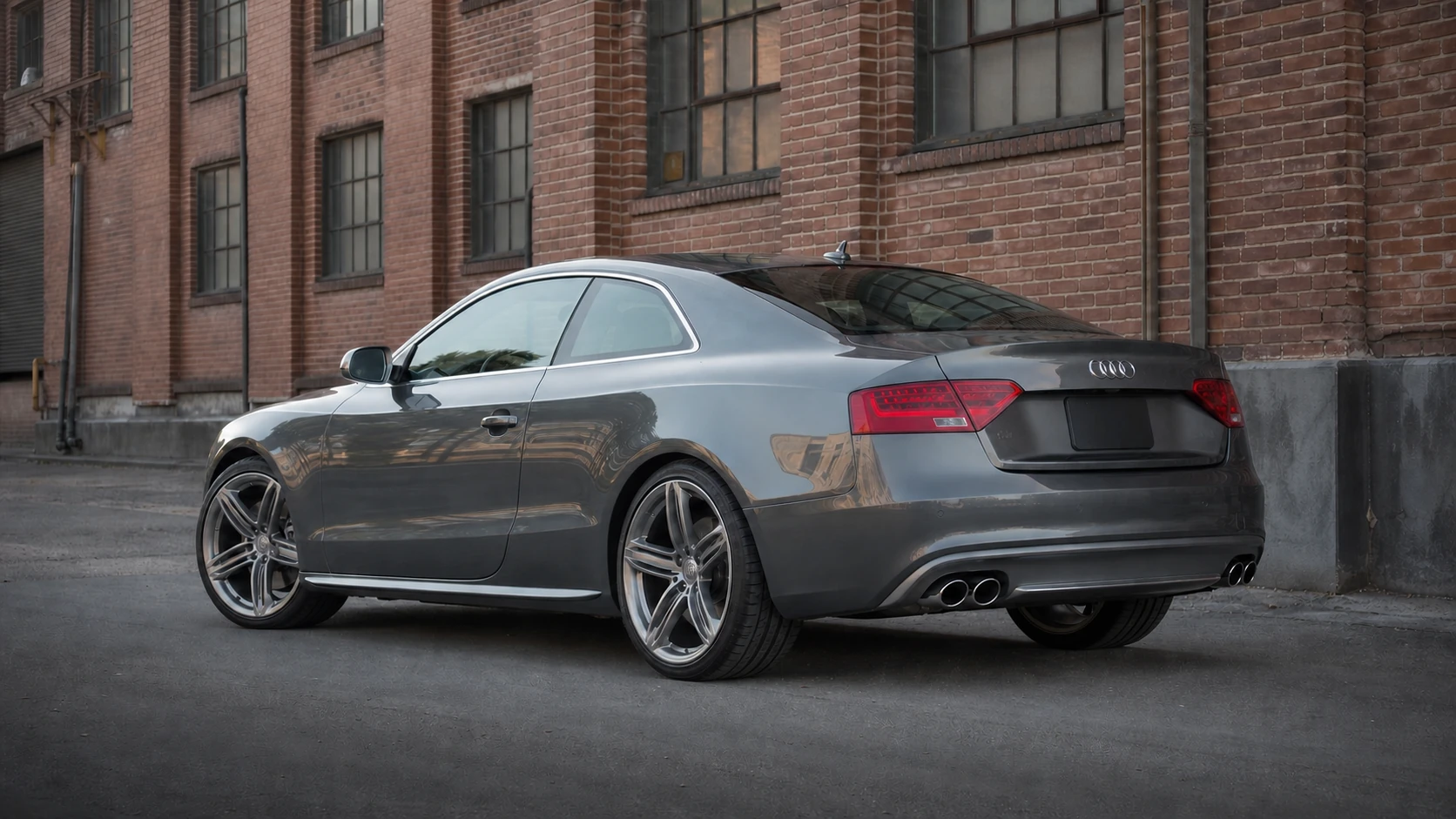 Gray B8.5 Audi S5 coupe beside a brick industrial building