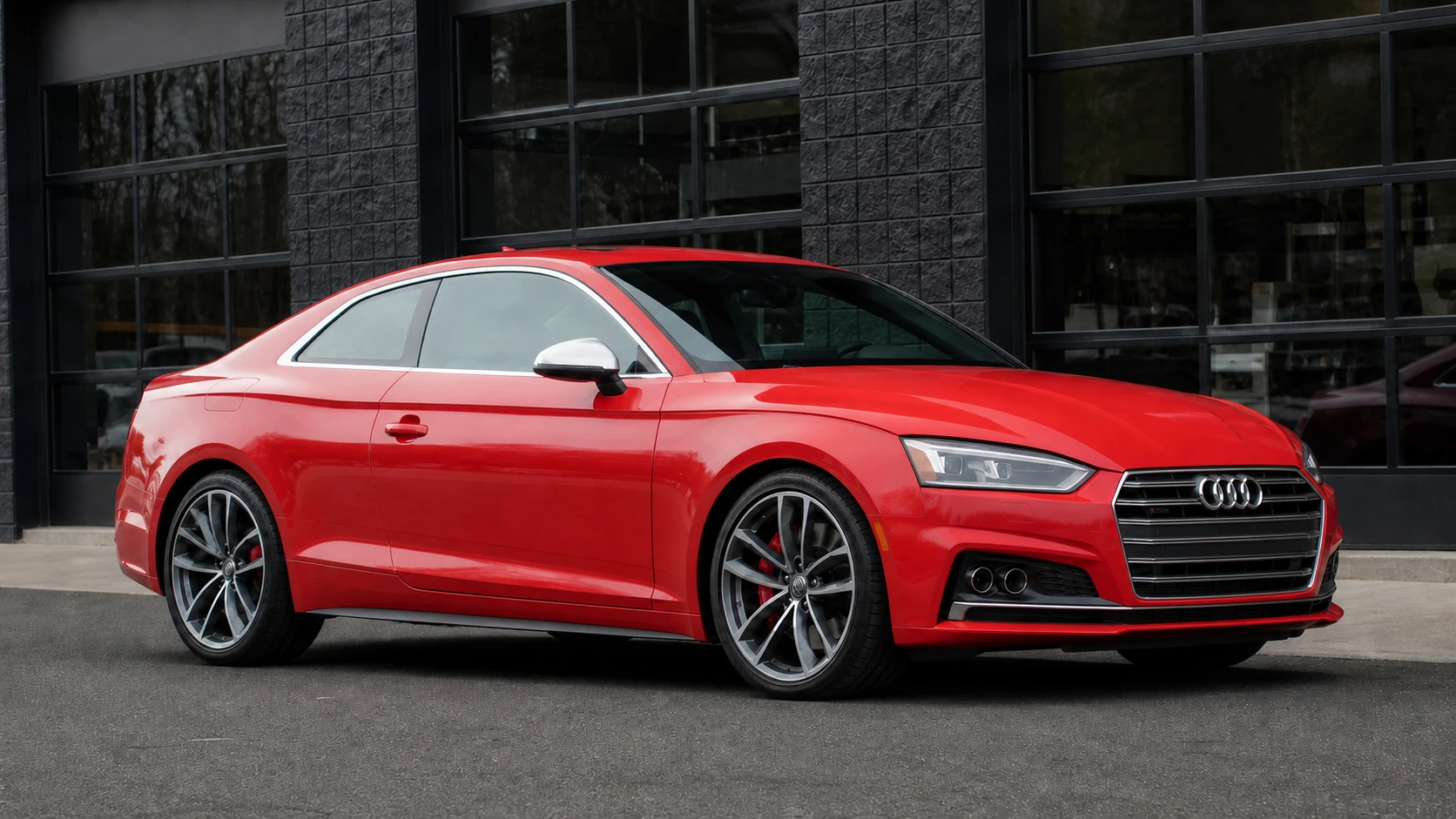 Red B9 Audi S5 coupe outside a dark performance facility