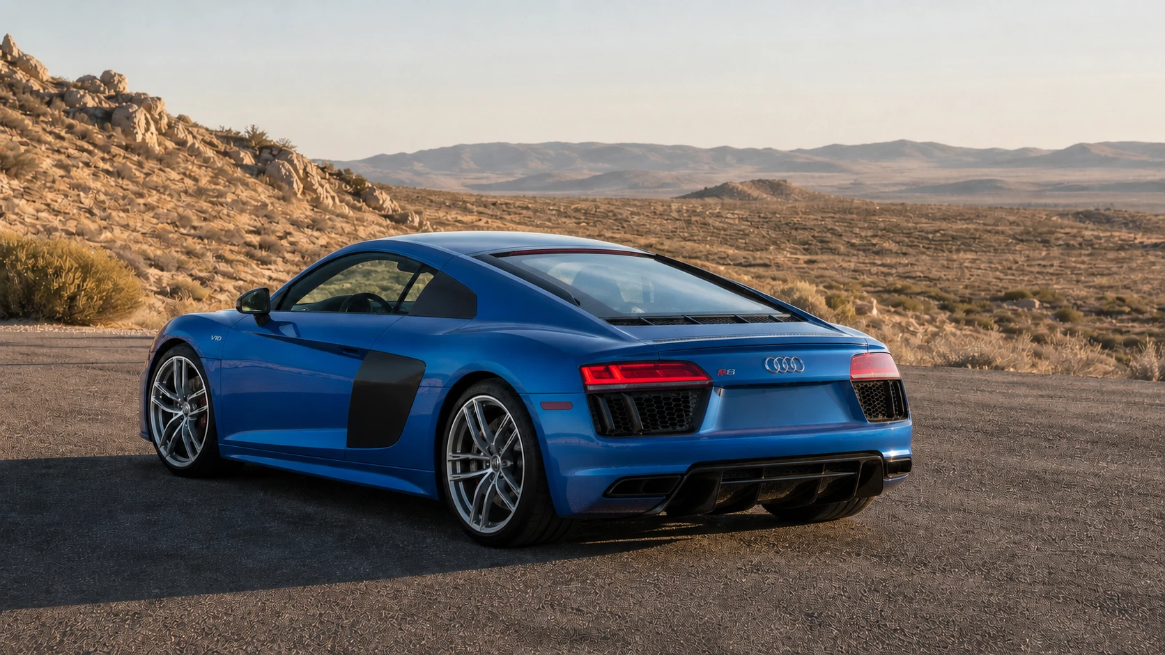 Blue second-generation Audi R8 in a rear three-quarter view at an open desert turnout