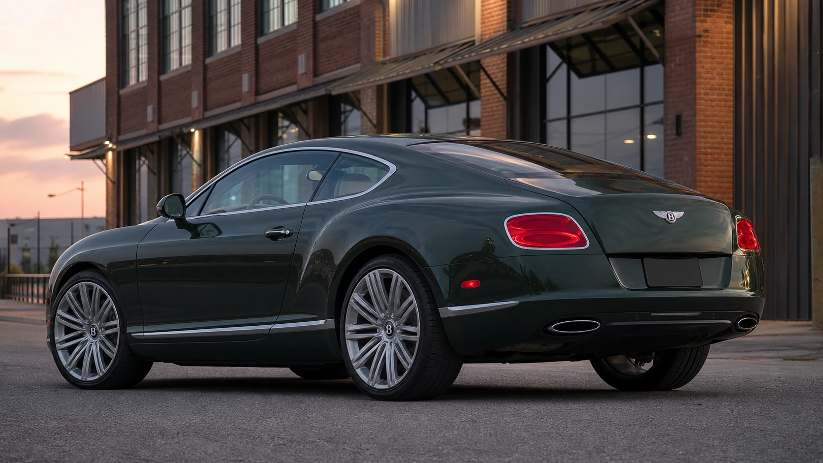 Green second-generation Bentley Continental GT outside a brick industrial building