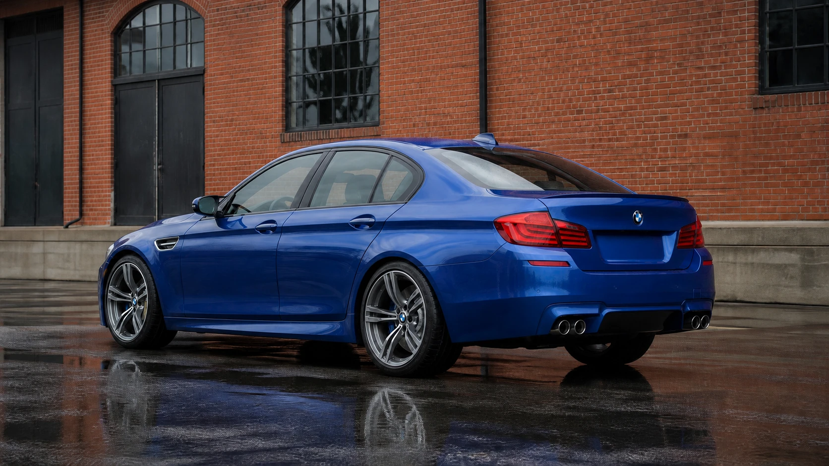 Blue F10 BMW M5 beside a brick industrial building for Cedar Performance tuning