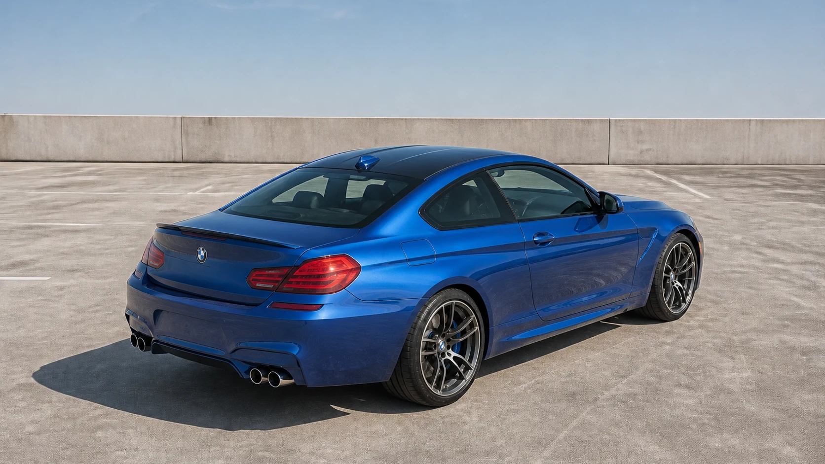 Blue F13 BMW M6 coupe in an elevated rear three-quarter view on an open parking deck