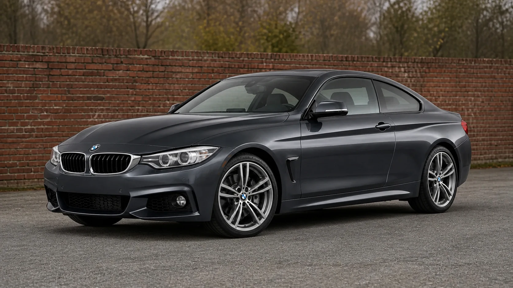 Dark gray F32 BMW 4 Series coupe beside a brick wall
