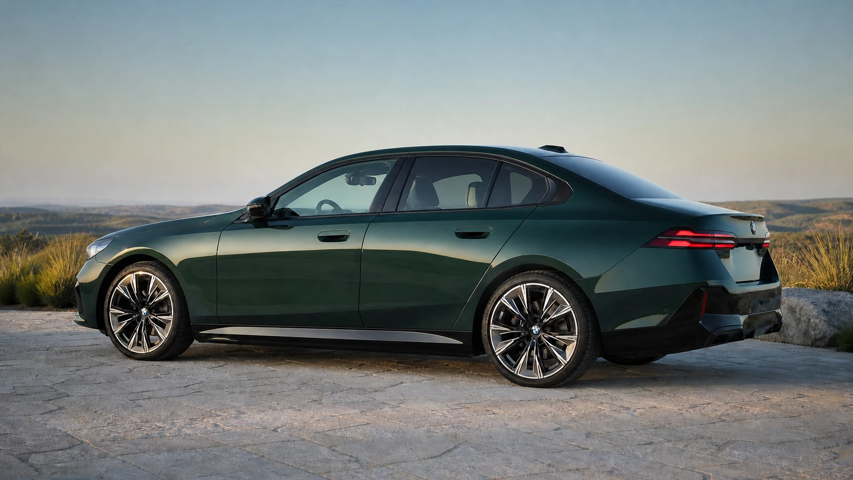 Green current-generation G60 BMW 540i sedan in a rear-biased profile at an open overlook