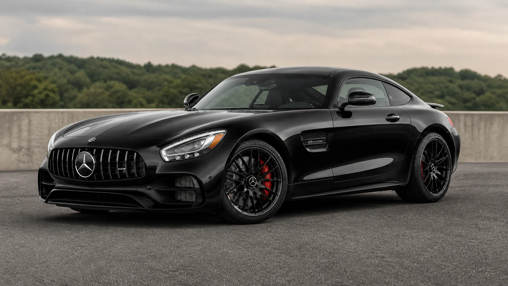 Black C190 Mercedes-AMG GT coupe at a quiet paved overlook