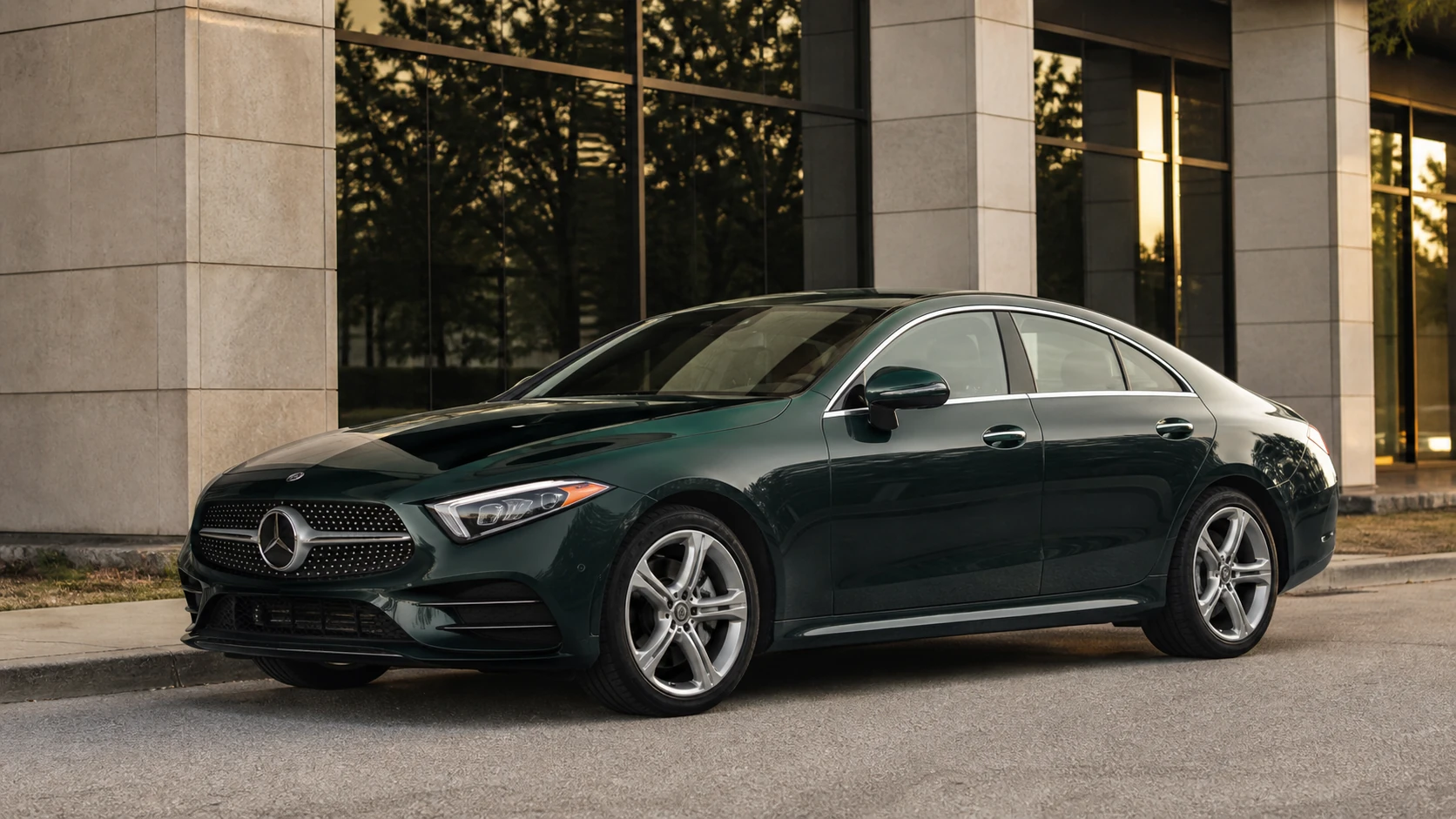 Green C257 Mercedes CLS outside a limestone commercial building