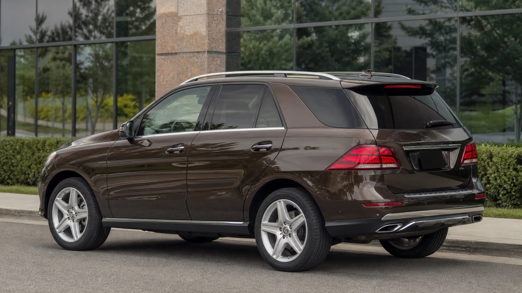 Brown W166 Mercedes GLE550 outside a glass commercial building