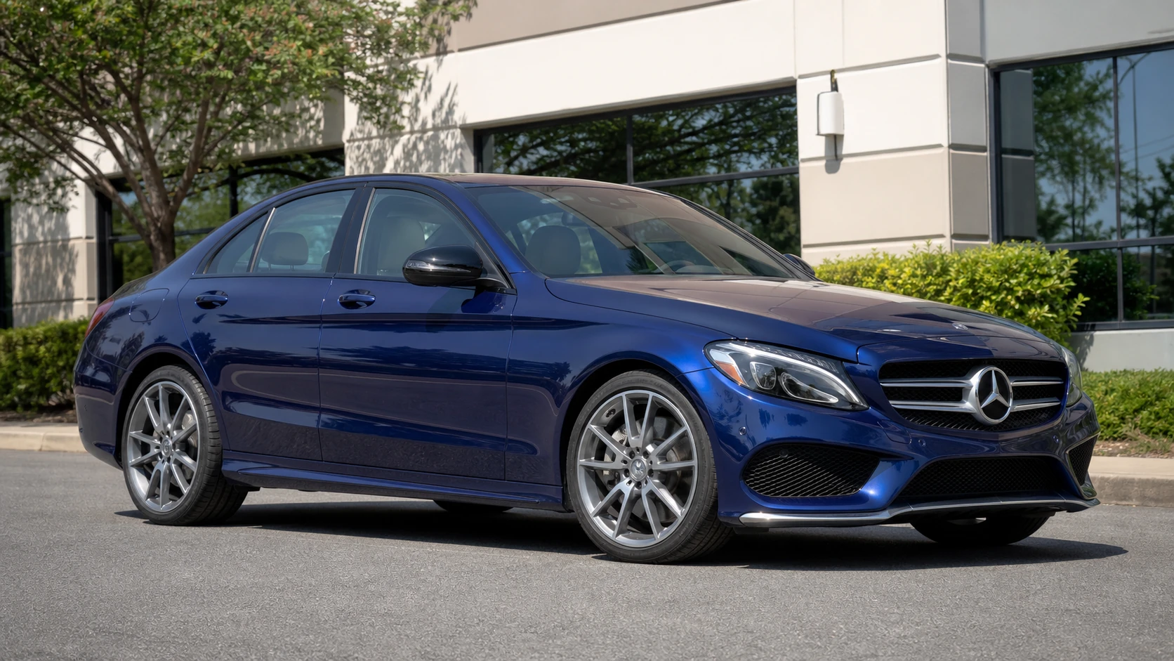 Blue standard-width W205 Mercedes sedan outside a commercial building
