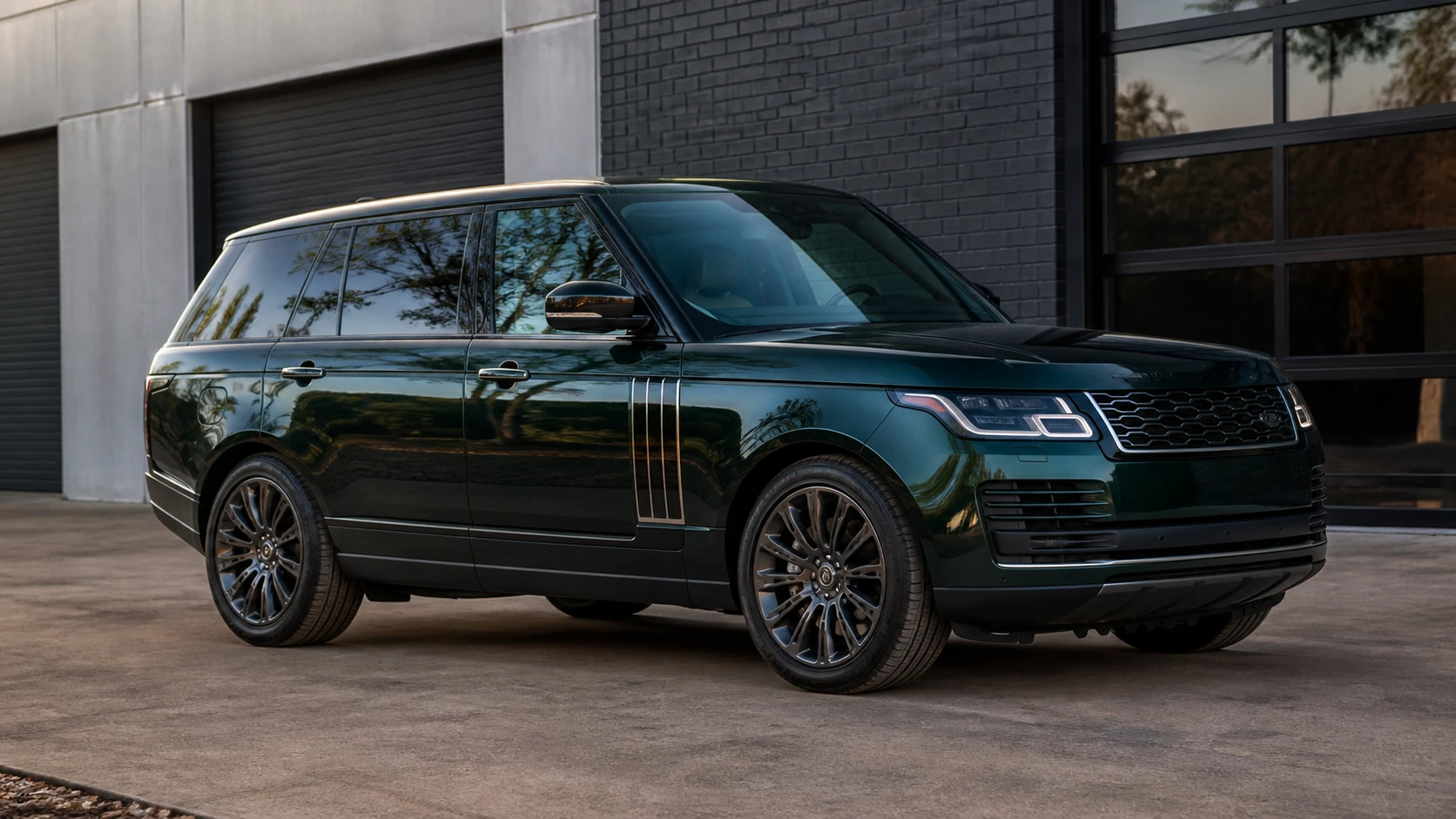 Green full-size L405 Range Rover outside a dark brick performance building